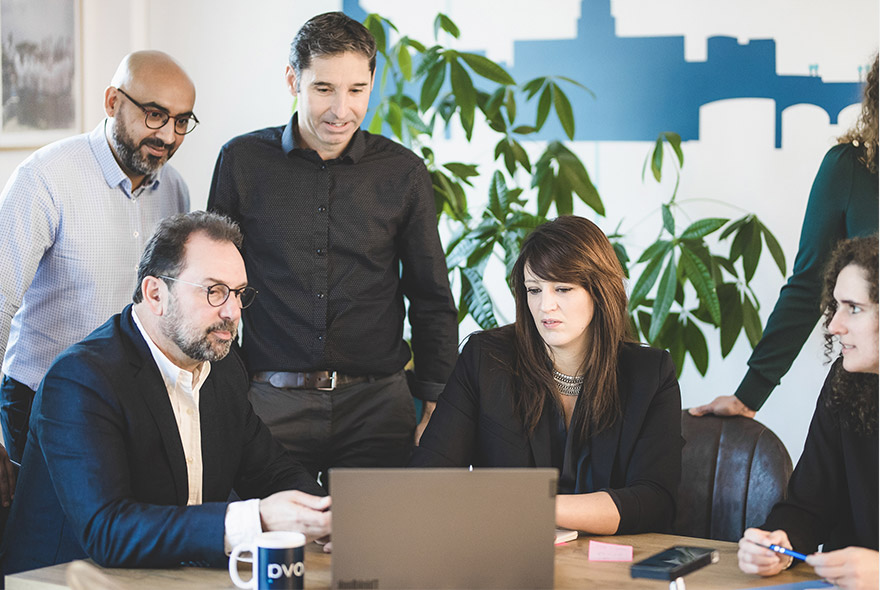 Ipanova team gathered around a laptop during a project meeting