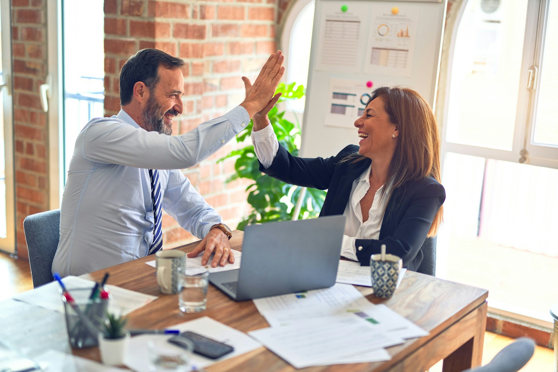 Two colleagues celebrating the completion of a digital transformation project